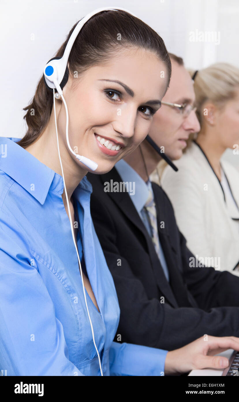 Happy business woman sur le téléphone dans un centre d'appel portant chemisier bleu. Banque D'Images