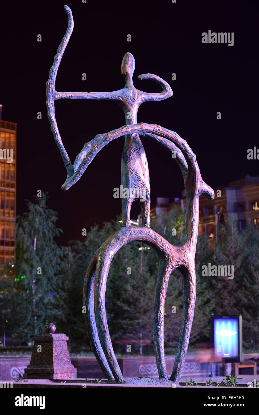 Une vue de la nuit d'une statue de bronze en pseudo-style primitif doté d''un rider sur l'arrière de tir à l'arc Banque D'Images