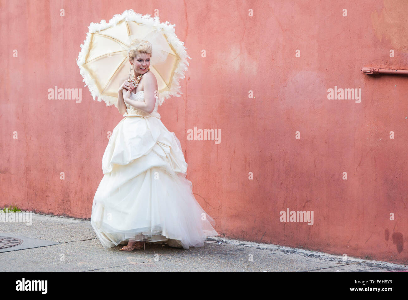 Modèle de l'Antebellum dress posing pour le photographe contre mur rose dans le quartier français de La Nouvelle-Orléans, Louisiane Banque D'Images