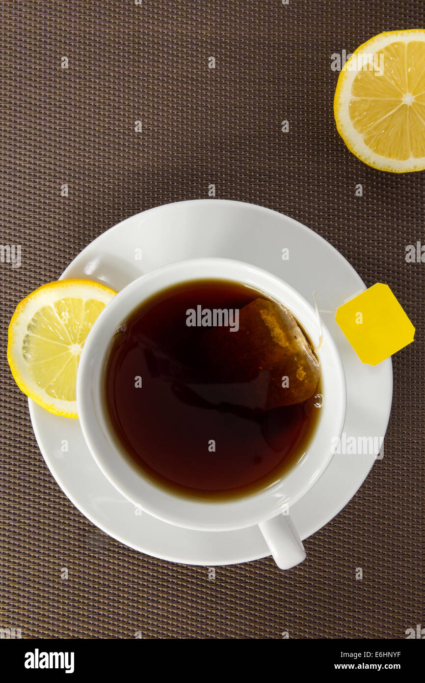 Vue aérienne de tasse de thé et tranche de citron sur fond brun Banque D'Images