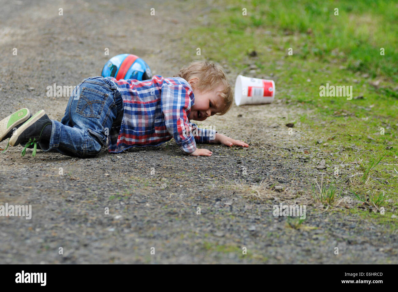 Un petit garçon, pleurer alors qu'il trébuche sur Banque D'Images