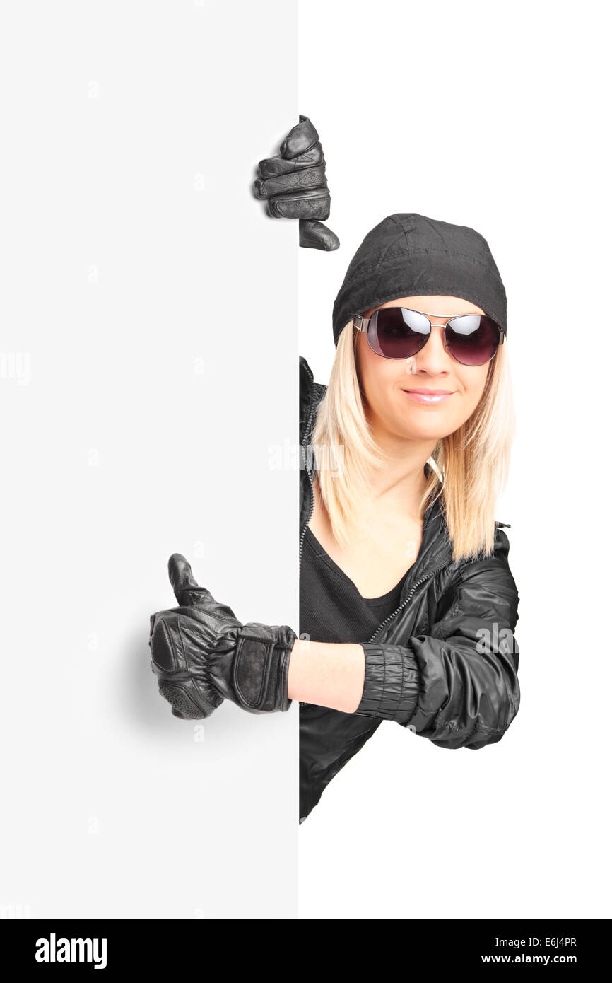 Femme biker giving thumb up derrière un panneau Banque D'Images