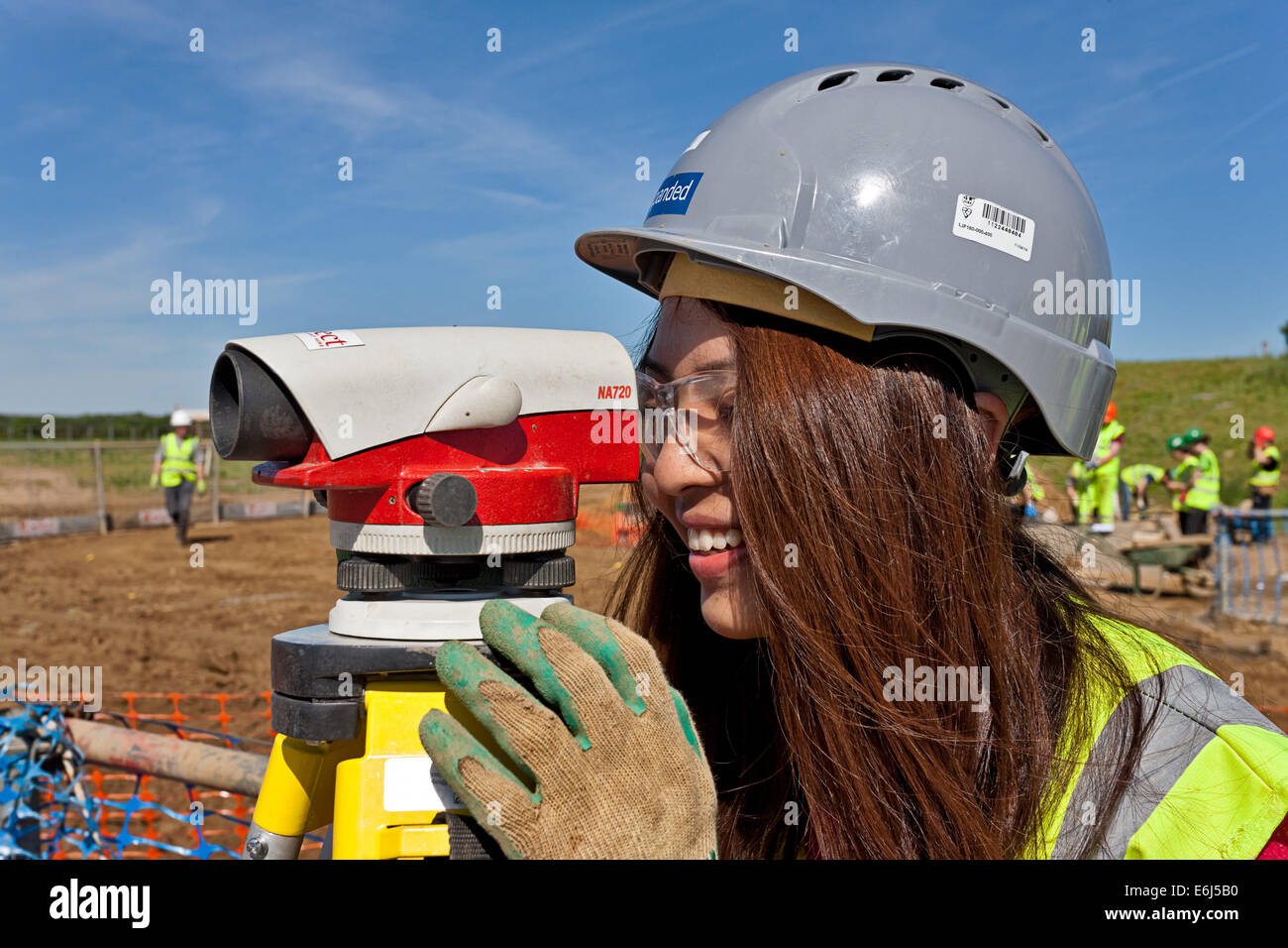 Chinese girl surveyor théodolite d'exploitation sur un site de construction Banque D'Images