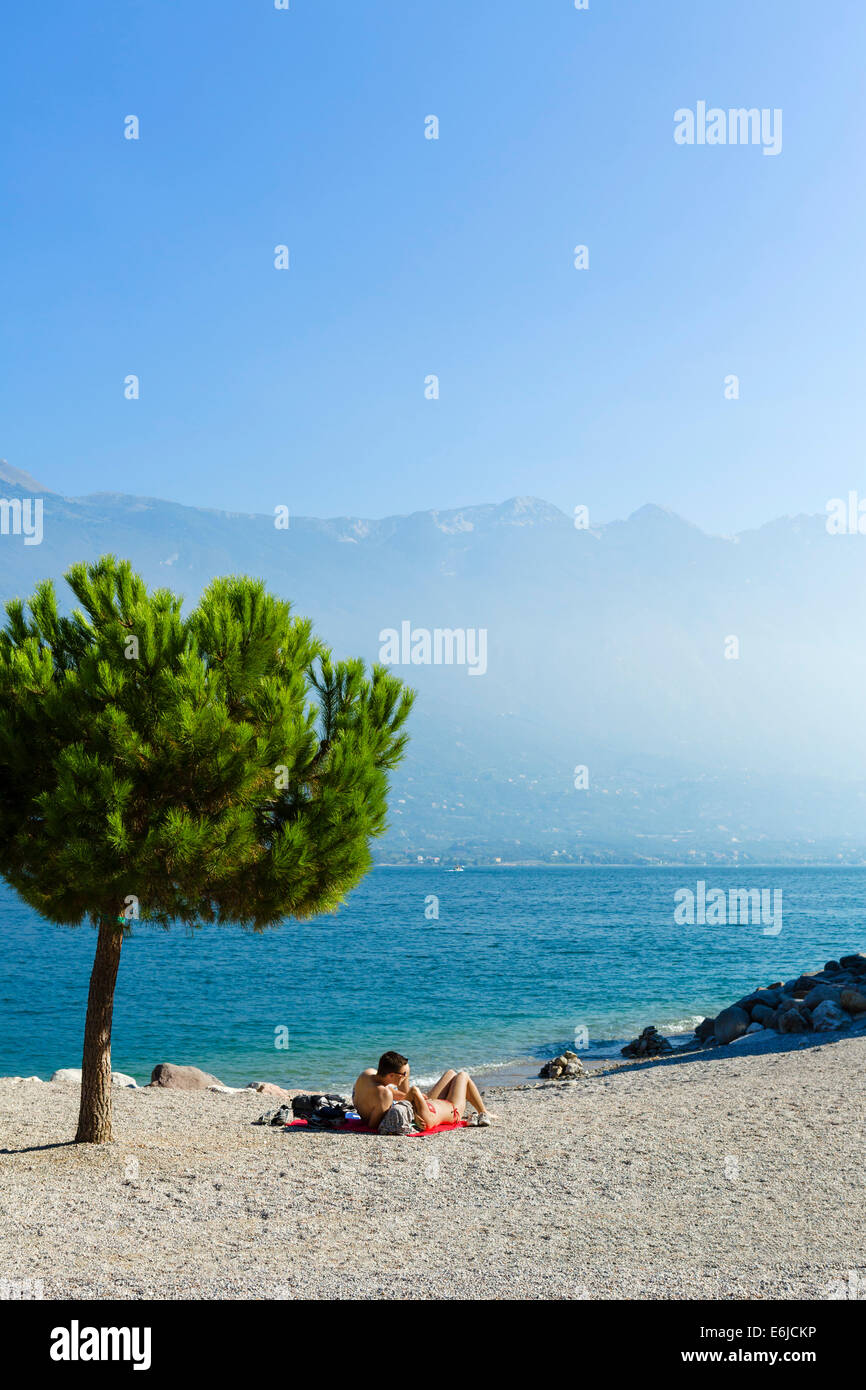 Jeune couple sur la plage à Limone sul Garda, Lac de Garde, Lombardie, Italie Banque D'Images