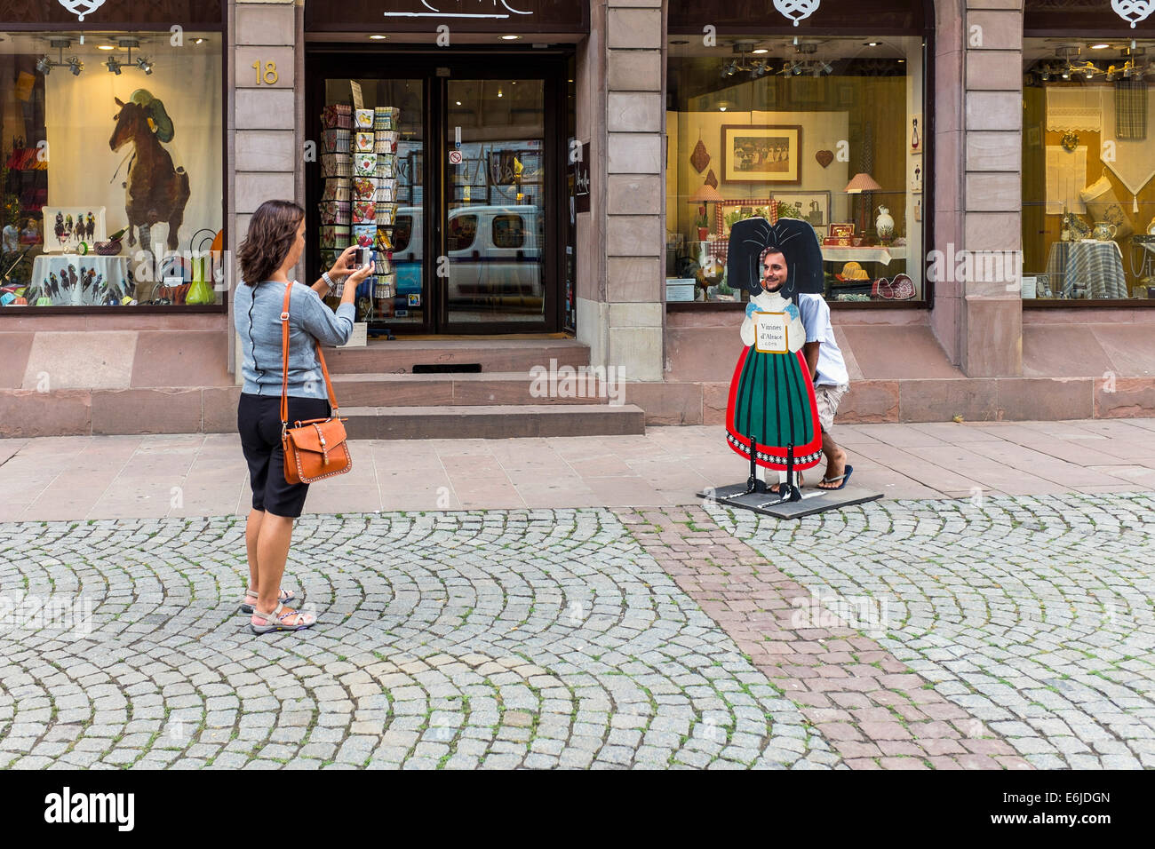 Femme prenant en photo l'homme avec sa tête dans le panneau de trous Strasbourg Alsace France Europe Banque D'Images