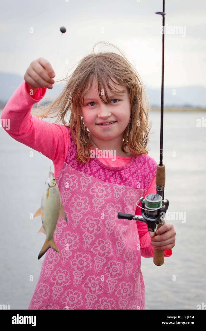 Young Girl holding up Chessa le poisson qu'il vient de prendre sur le fleuve Zambèze. Banque D'Images