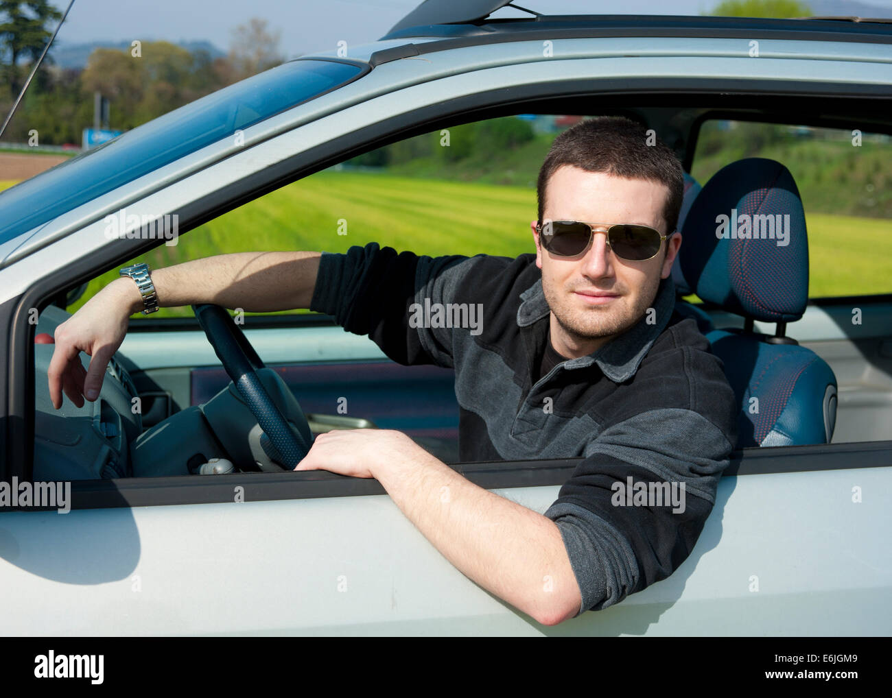 L'homme au volant de sa voiture et le port de lunettes de soleil Photo  Stock - Alamy