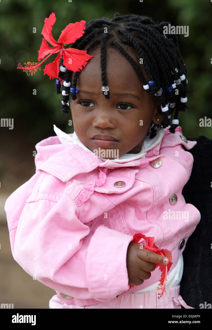 Jeune fille africaine (20 mois) avec hibiscus flower in her dread locks. Nairobi, Kenya Banque D'Images