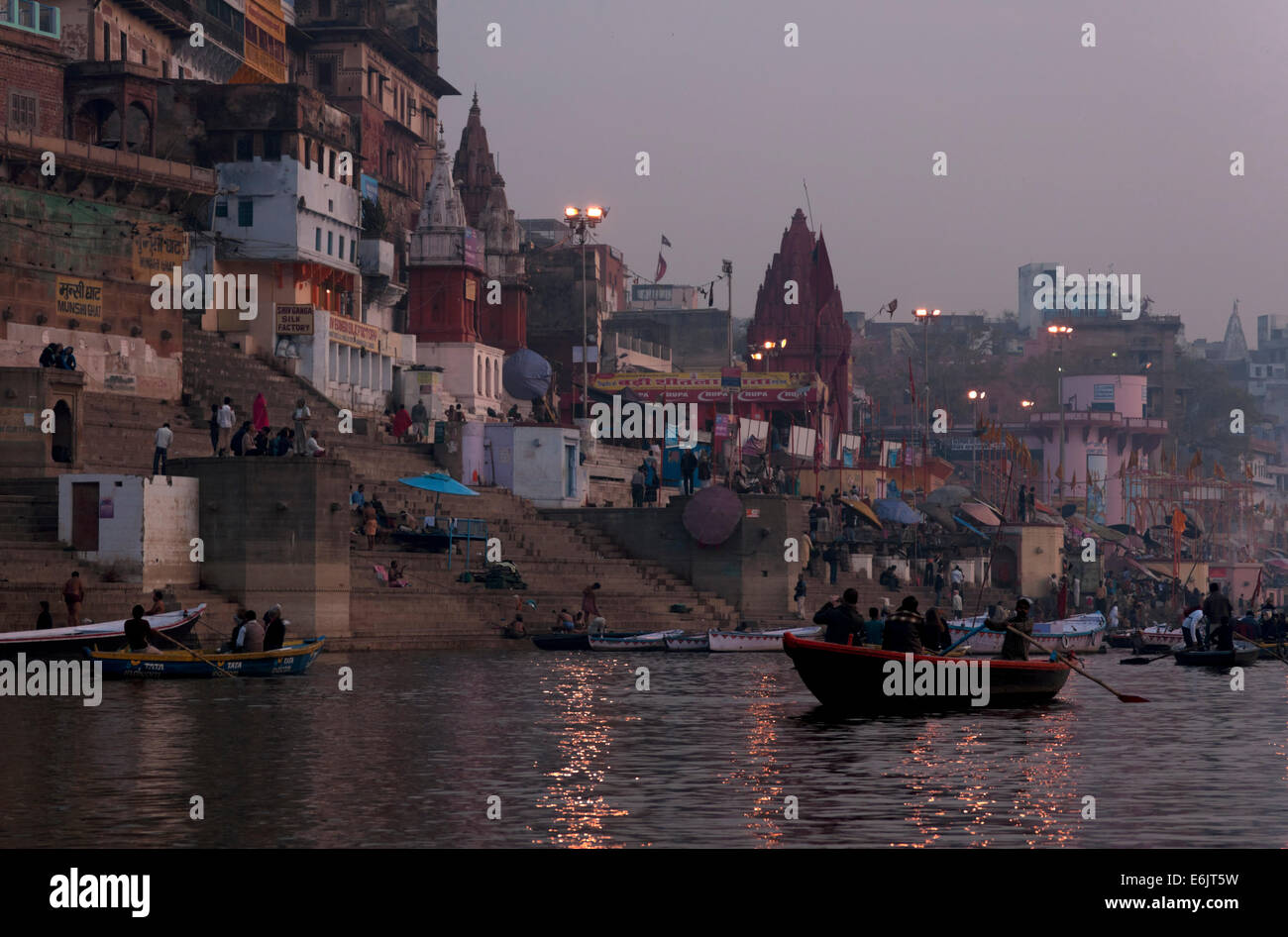 L'eau reflète certains des feux du matin sur le rivage à Varanasi. Banque D'Images