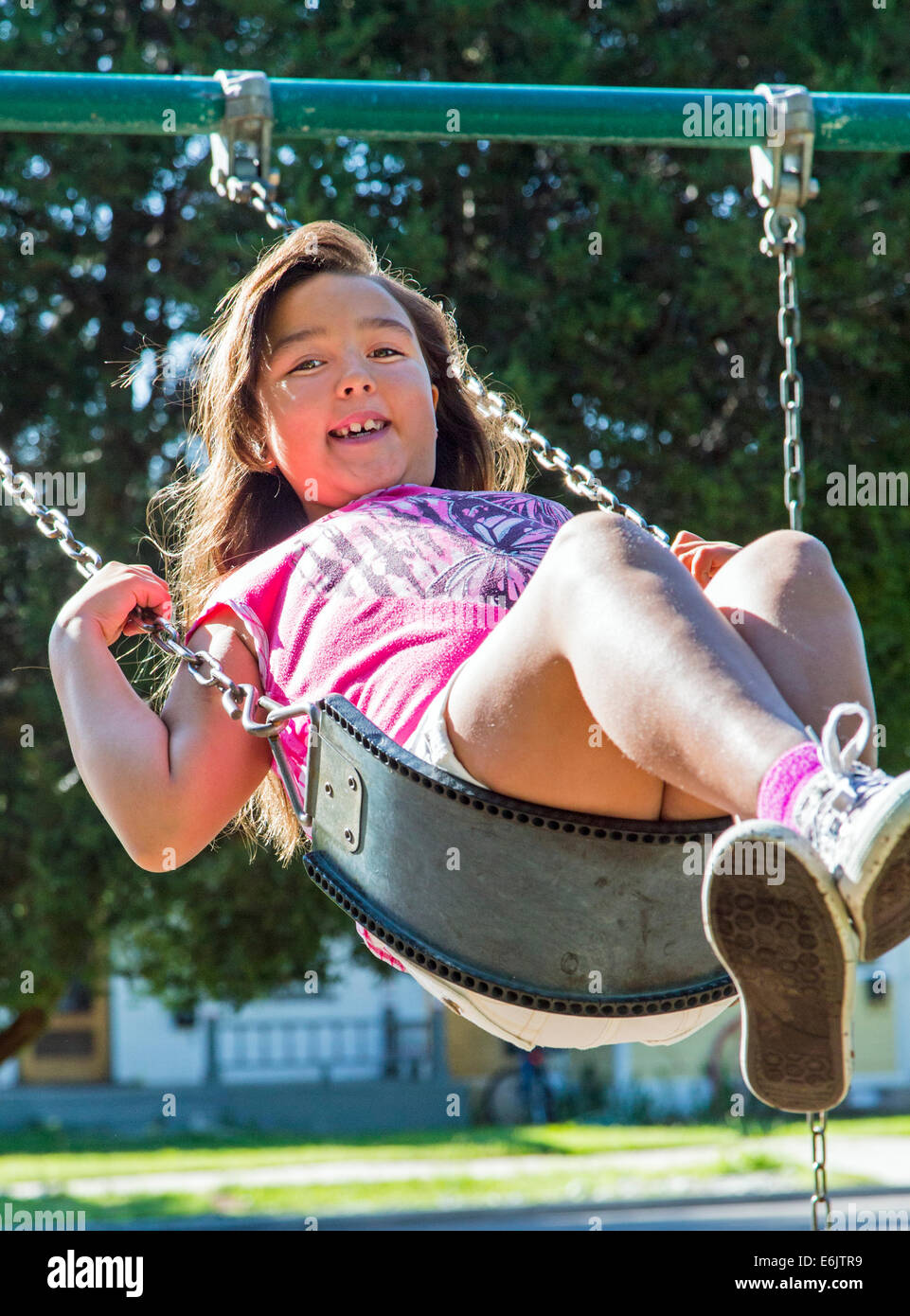 Photographie d'été de sept ans, fille, sur une aire de swing Banque D'Images