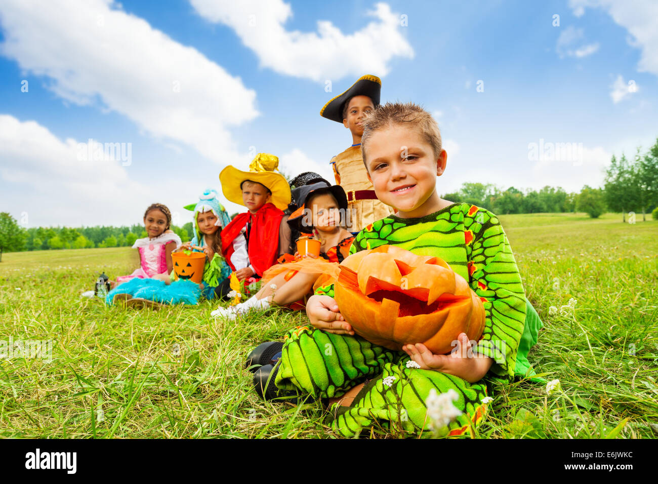 Groupe d'enfants en costumes de Halloween assis Banque D'Images
