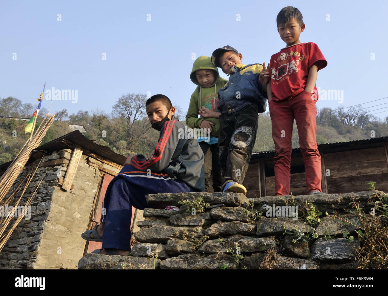 Les enfants me regardent à partir de mur de pierre,région de l'Himalaya, Népal, Asie Banque D'Images