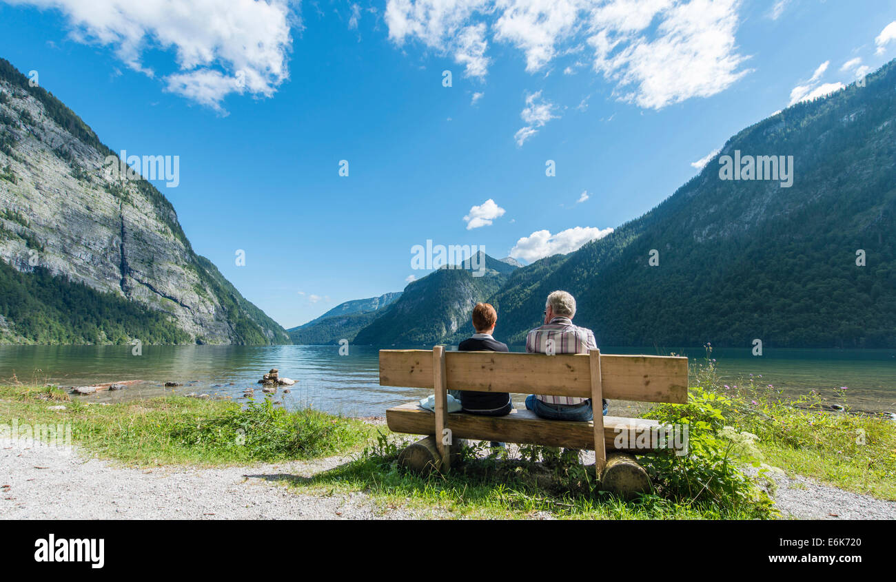 Deux personnes assises sur un banc, à la recherche sur le lac Königssee, St Bartholomä à Königssee, le parc national de Berchtesgaden Banque D'Images