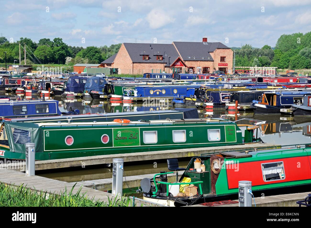 Narrowboats sur leurs amarres dans le bassin du canal avec des bars, boutiques et restaurants à l'arrière, Barton-under-Needwood, UK. Banque D'Images