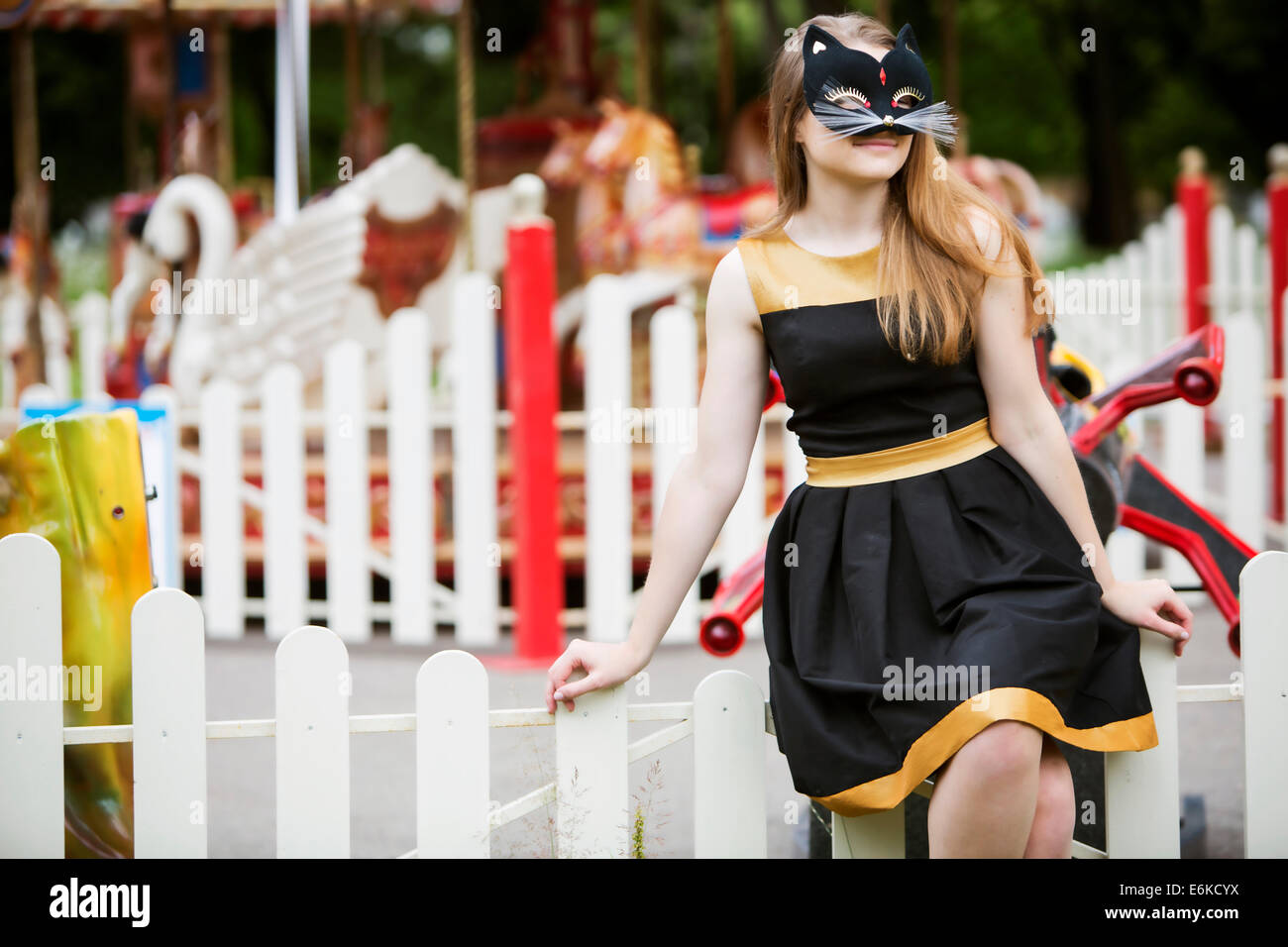 Jeune femme avec masque sur fond carrousel vide Banque D'Images