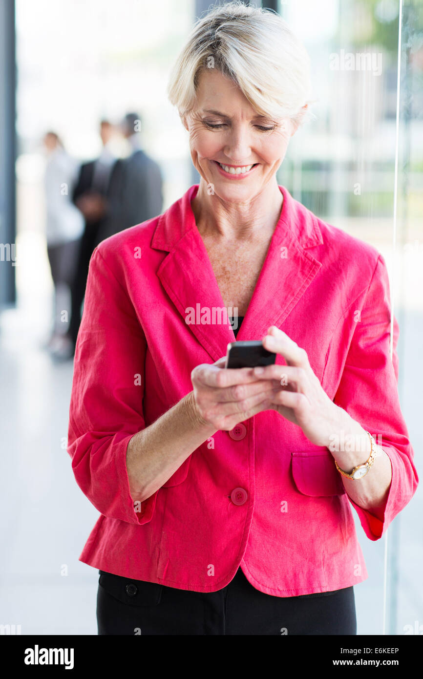 Happy businesswoman using smart phone in office Banque D'Images