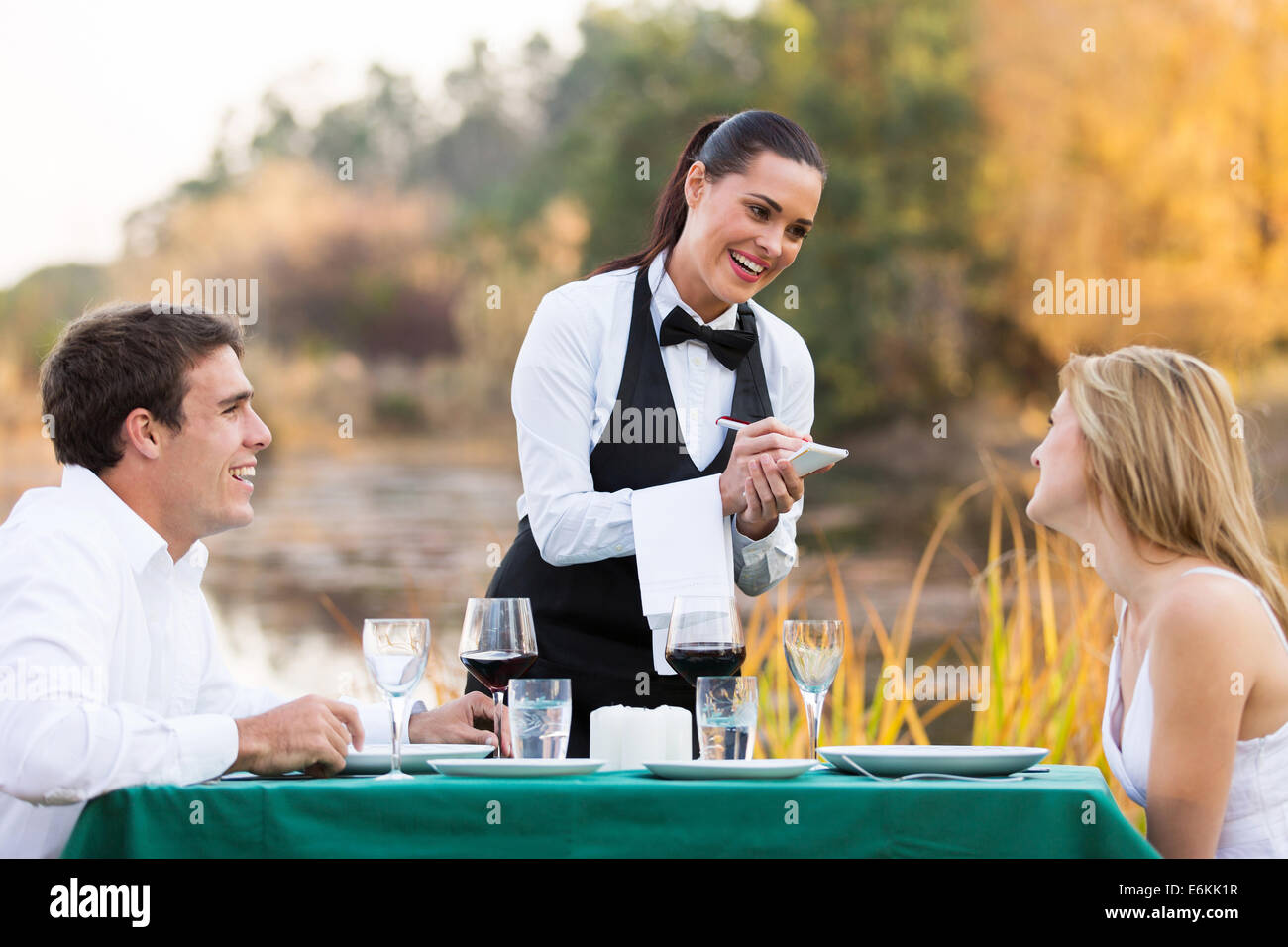 Friendly female waitress de cute young couple Banque D'Images