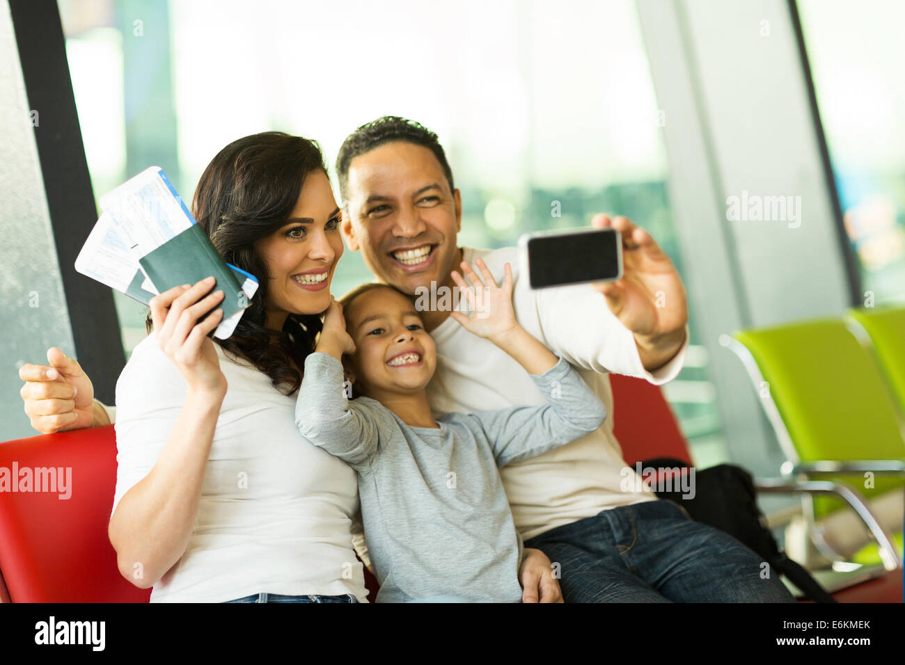 Famille heureuse à l'aéroport taking self portrait with smart phone at airport Banque D'Images
