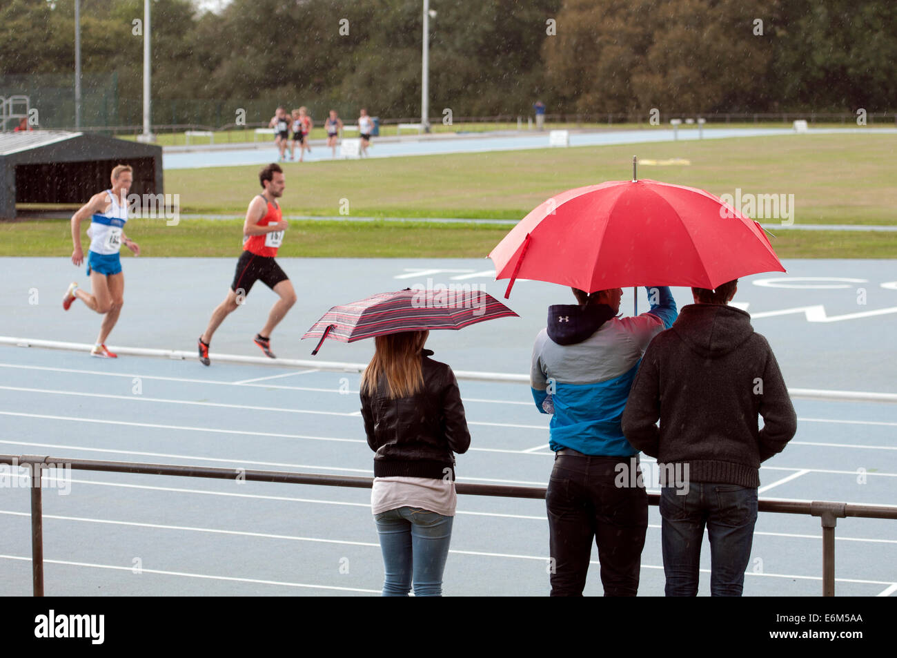 Les spectateurs d'athlétisme avec parasols Banque D'Images