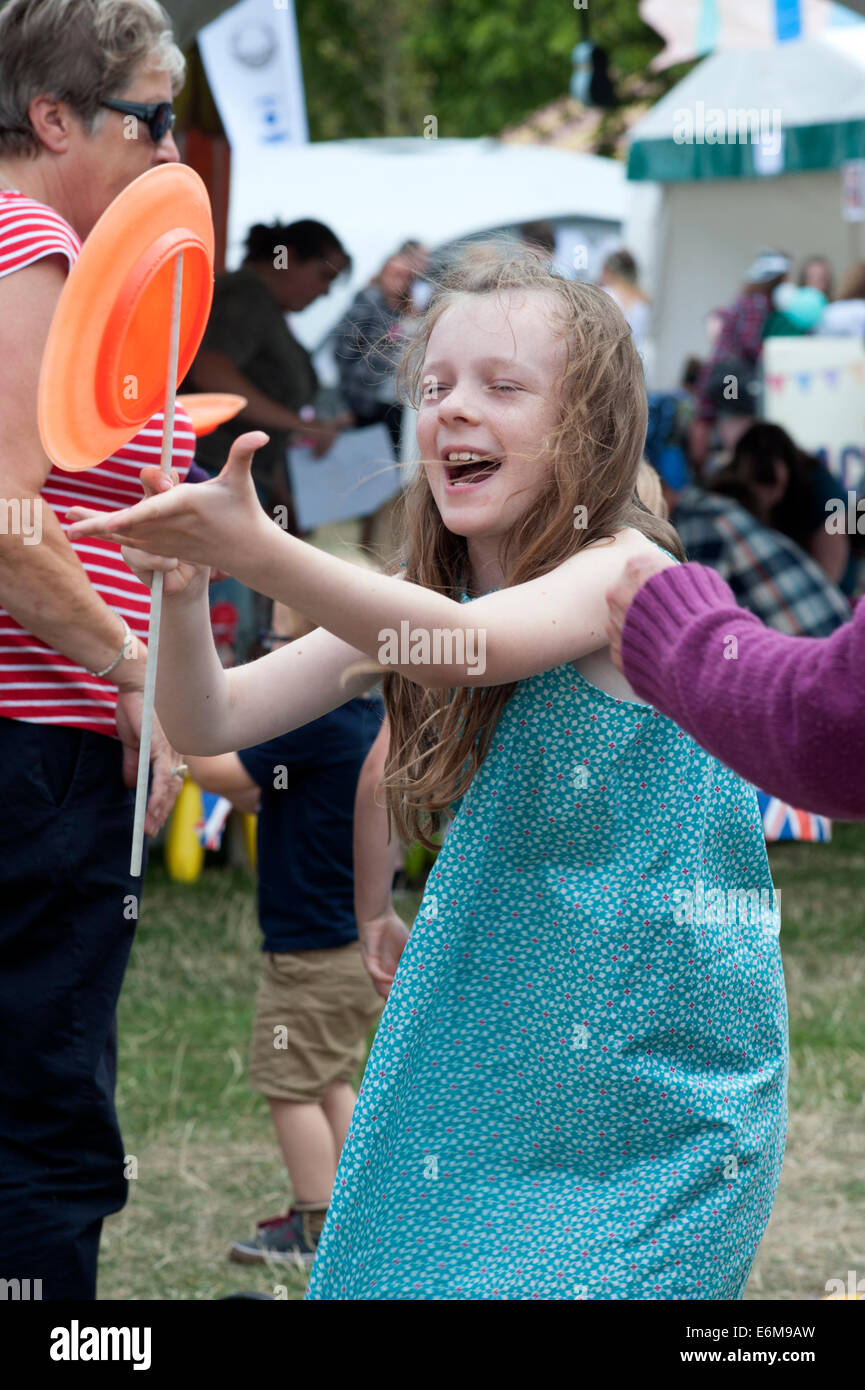 Jeune fille riant de tenter de tourner la plaque à la victorieuse festival 2014 england uk southsea Banque D'Images