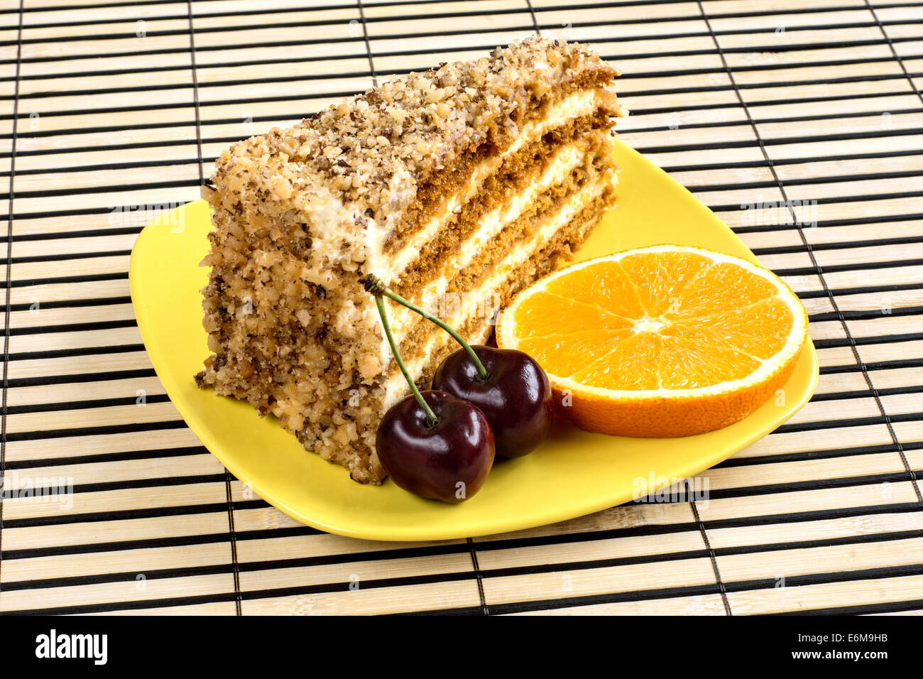 Walnut cake garni d'une cerise et de tranche d'orange. Banque D'Images