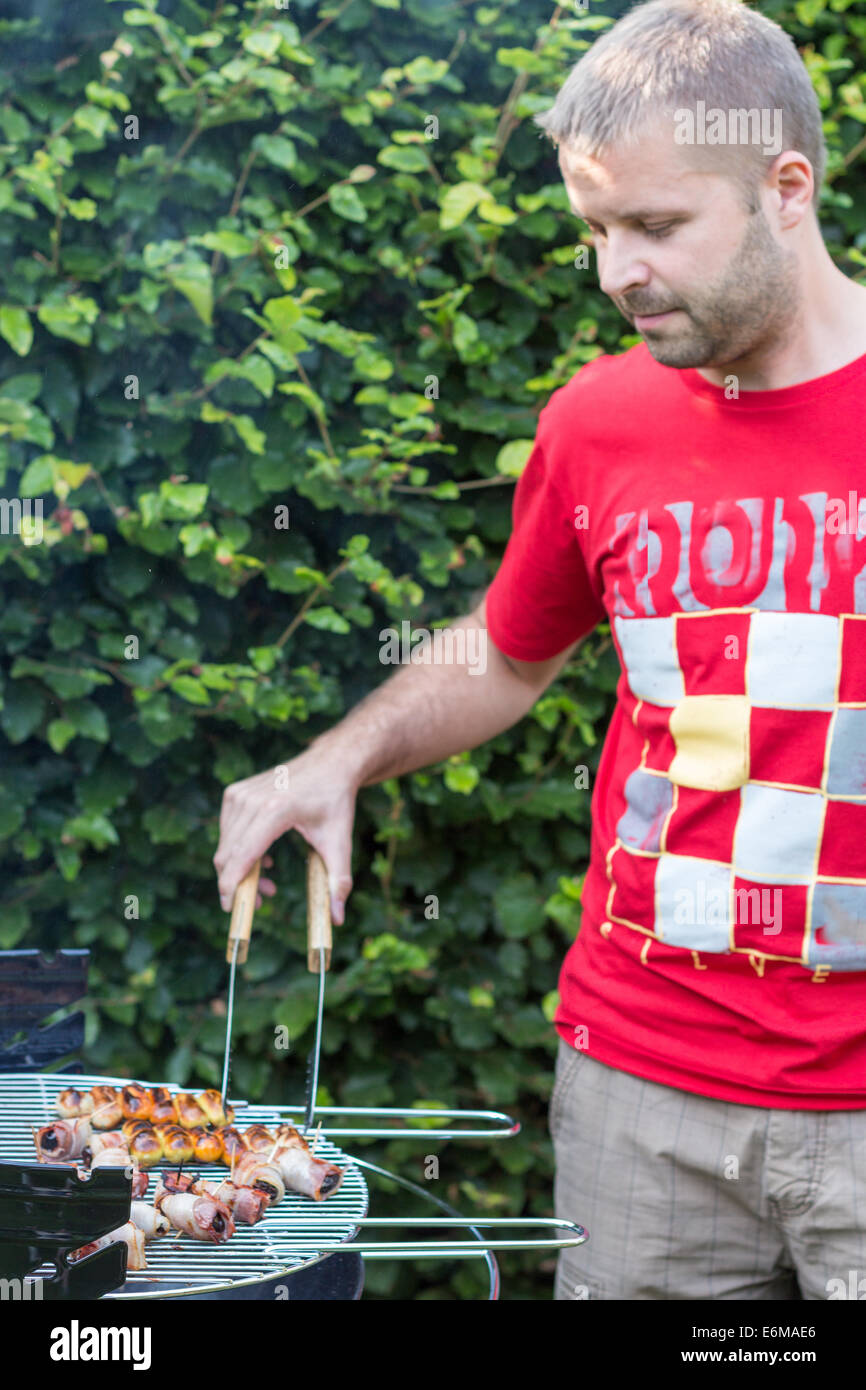 L'homme la cuisson des viandes sur le barbecue - côté droit Banque D'Images