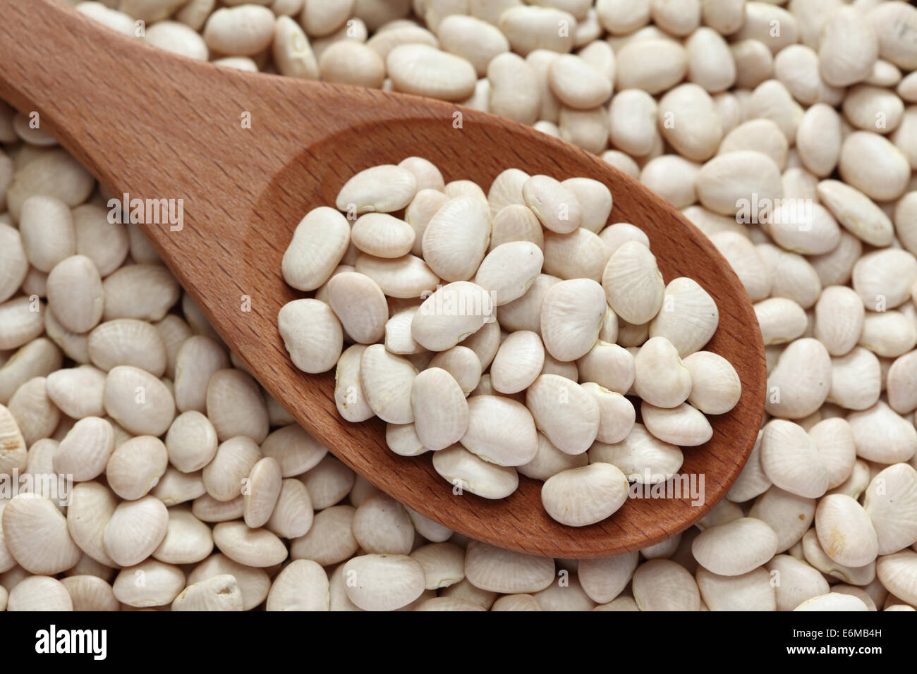 Les haricots de Lima dans une cuillère en bois sur les haricots de lima. Banque D'Images