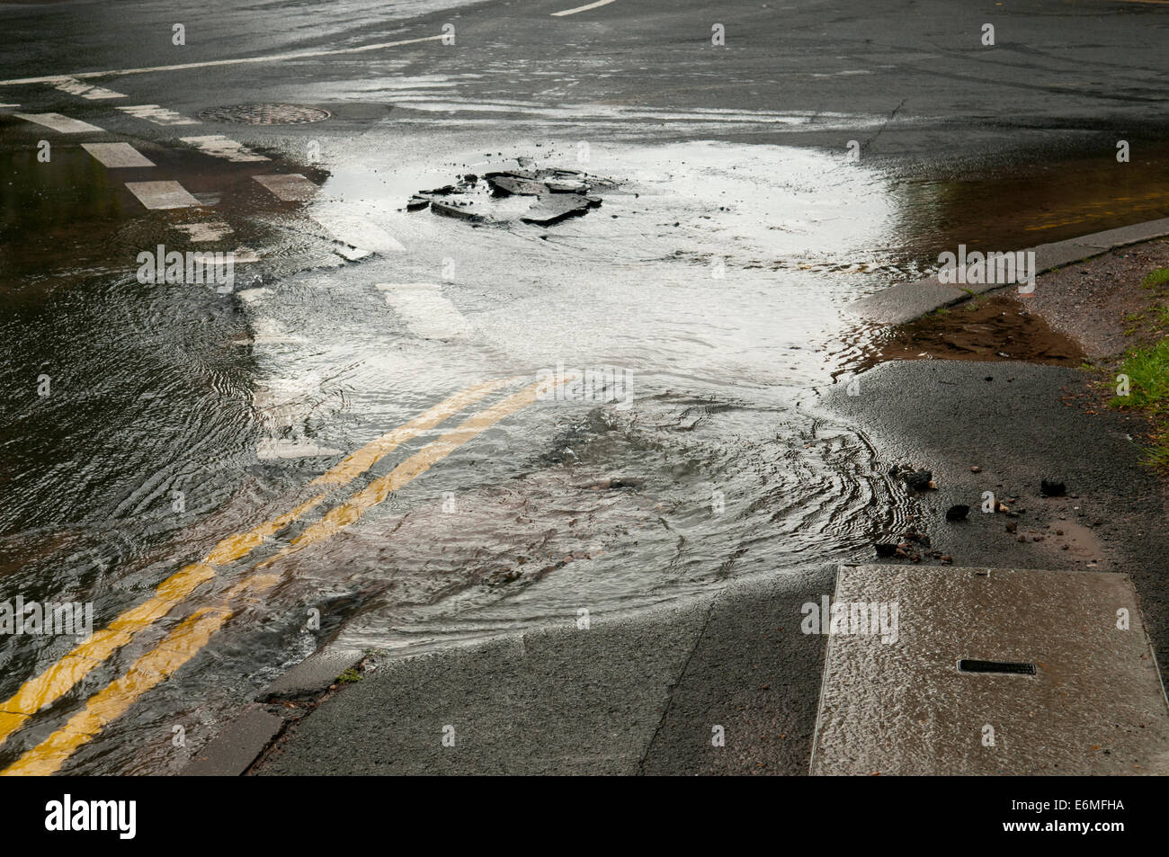 Fuite d'eau d'une rafale d'eau principale dans la route Banque D'Images