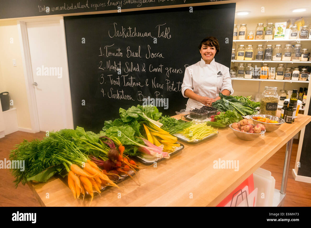 Instructeur Chef Mariana Brito avec la gamme de produits frais qui va devenir une merveilleuse salade à SchoolHaus Arts Culinaires Banque D'Images