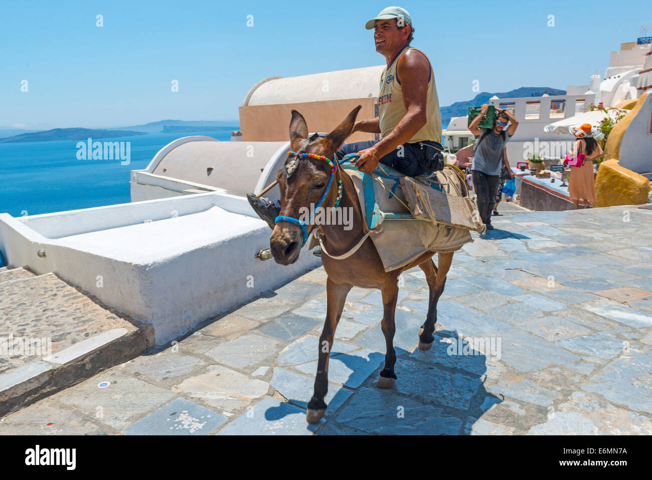 OIA, Santorin, GRÈCE - 22 juillet 2014 : l'homme est un âne par temps chaud à Oia, Santorin, Grèce.Les touristes seront tra Banque D'Images