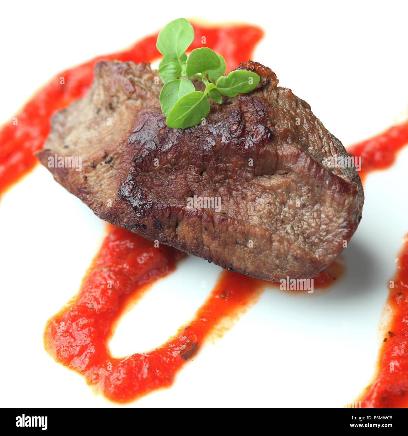 Rôti de boeuf avec sauce tomate et basilic. Arrière-plan blanc. Close-up. Banque D'Images