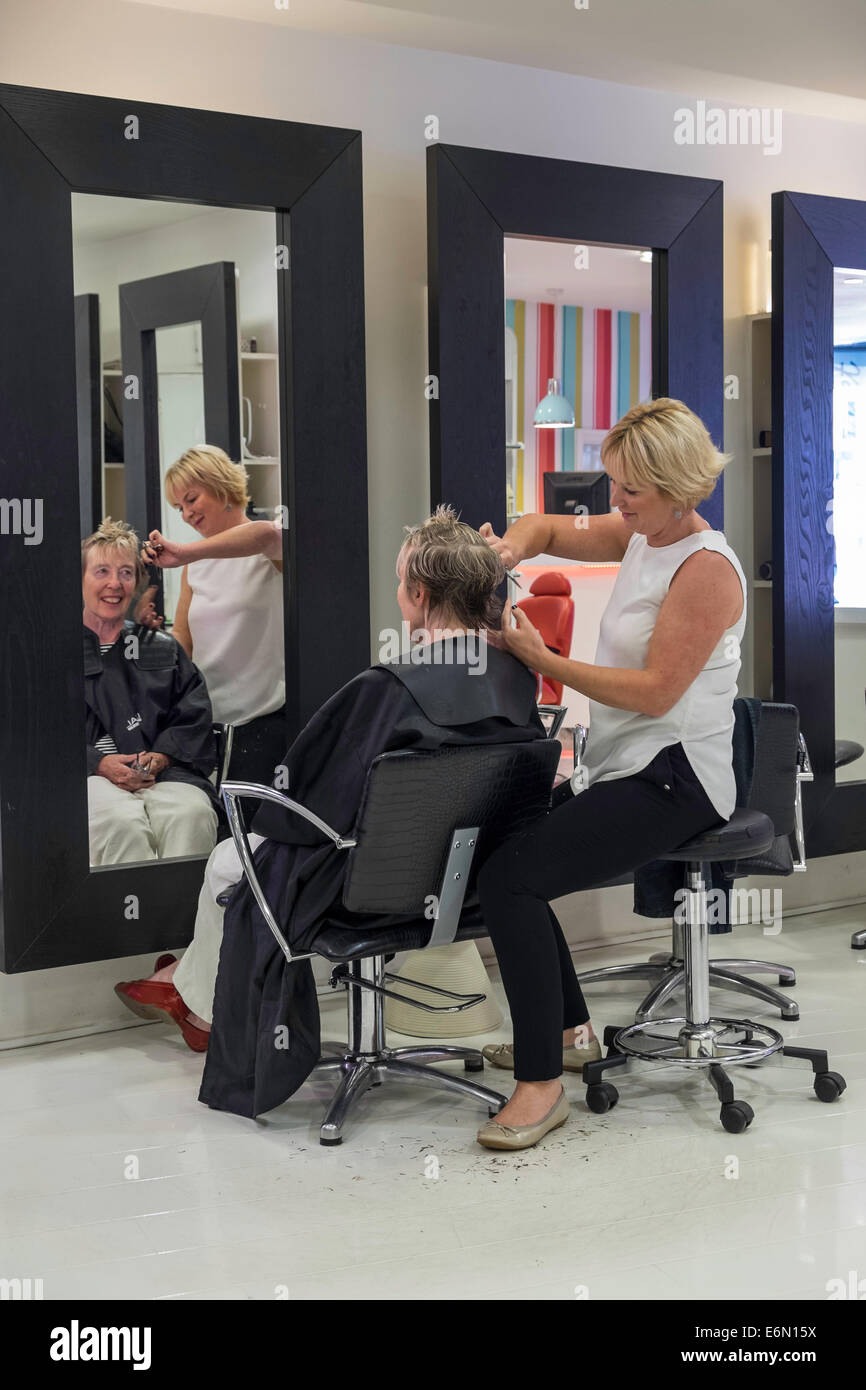 Vieille Femme faisant couper les cheveux dans un salon de coiffure avec coiffure Banque D'Images