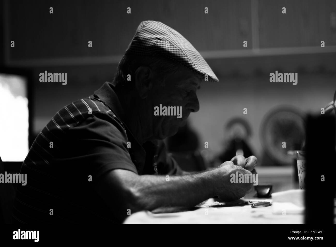Old man sitting at table Banque D'Images