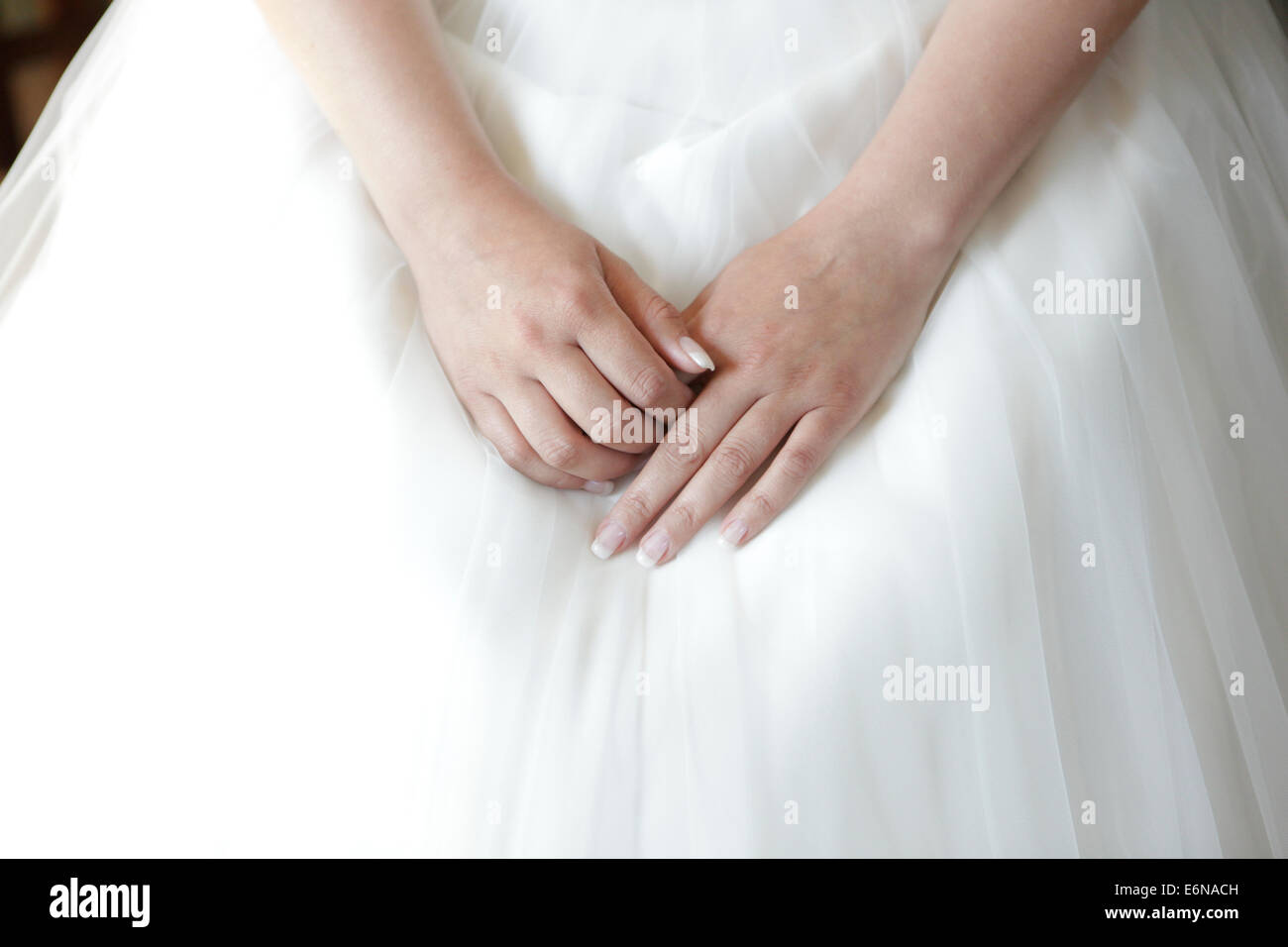 Les mains de la mariée se trouvant sur la robe nuptiale Banque D'Images