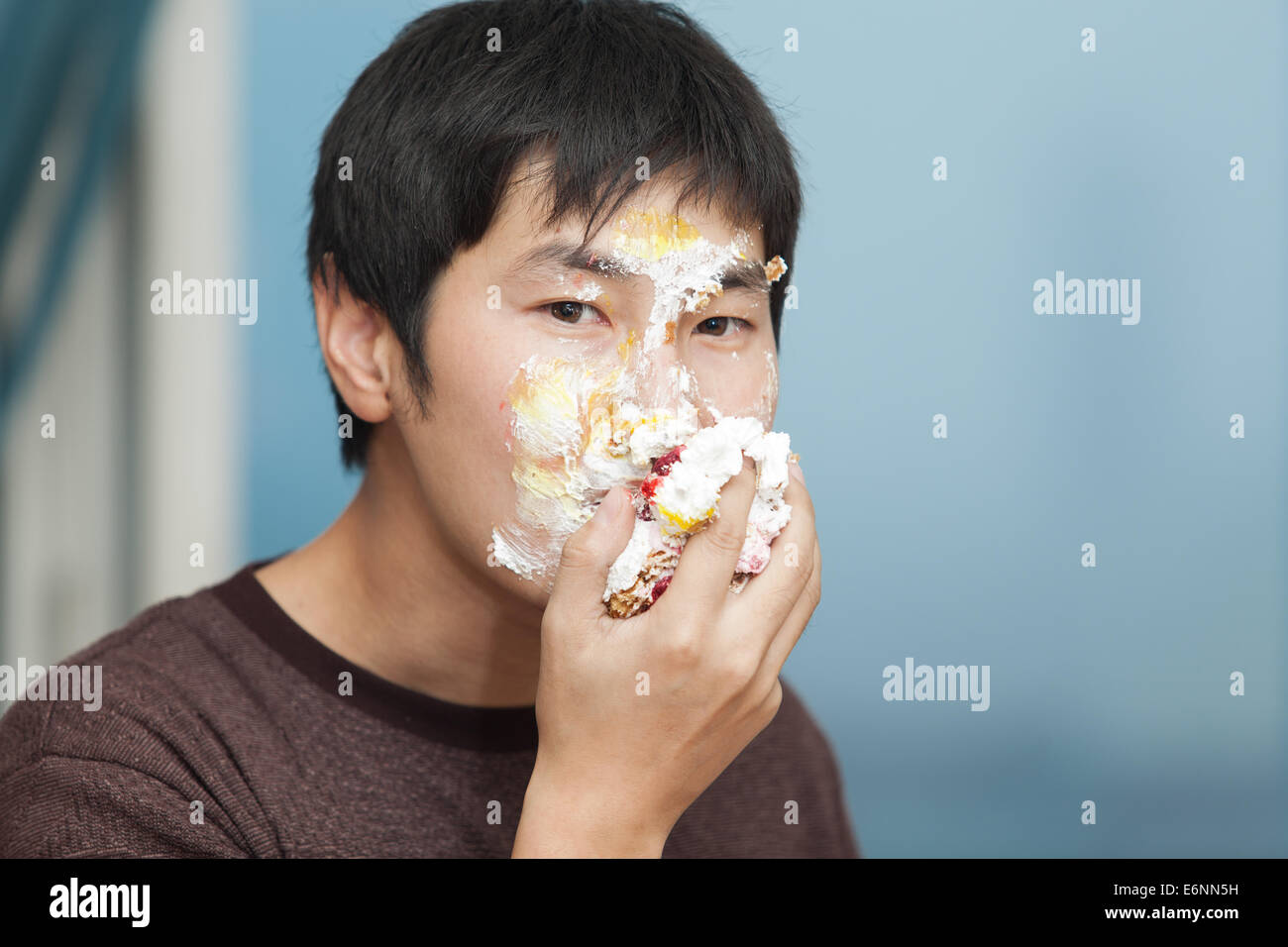 Les hommes de manger un morceau de gâteau enduit de crème glacée Banque D'Images