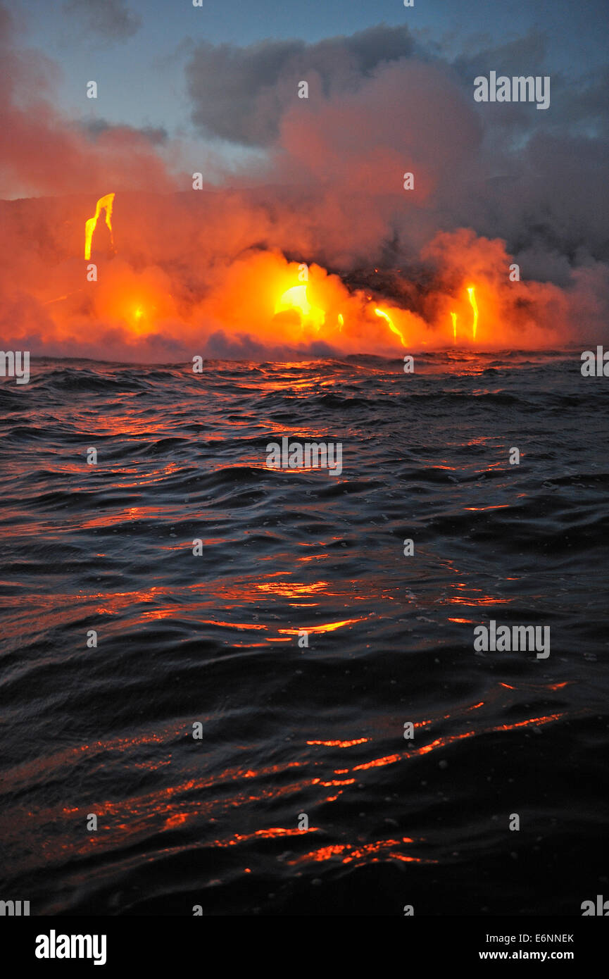 L'augmentation de vapeur au large de l'océan qui s'écoule dans la lave au crépuscule, Kilauea Volcano, Big Island, Hawaii Volcanoes National Park, États-Unis Banque D'Images