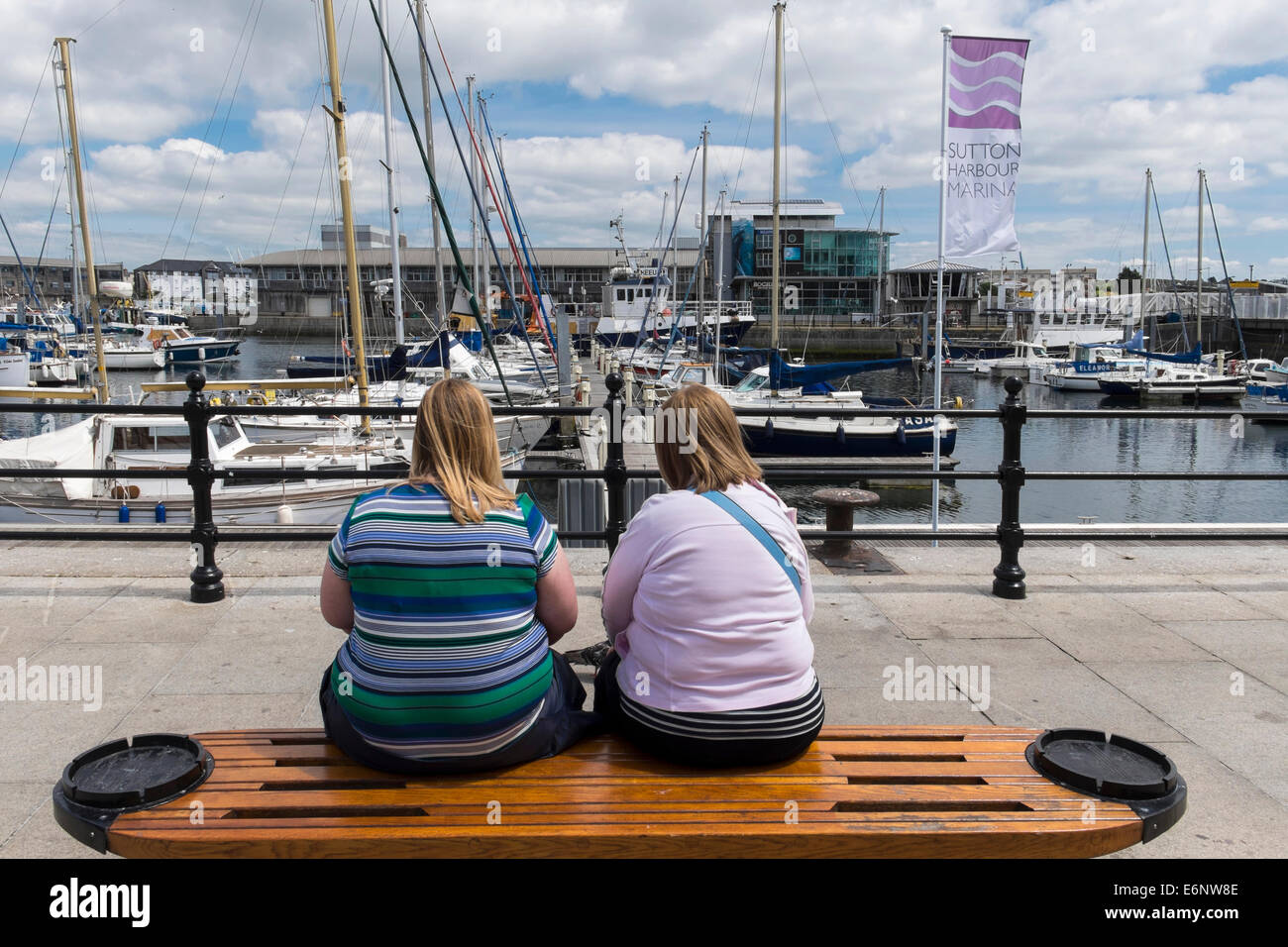 Deux femmes assises sur un banc sur Barbican de Plymouth, Plymouth, Devon, England, UK Banque D'Images