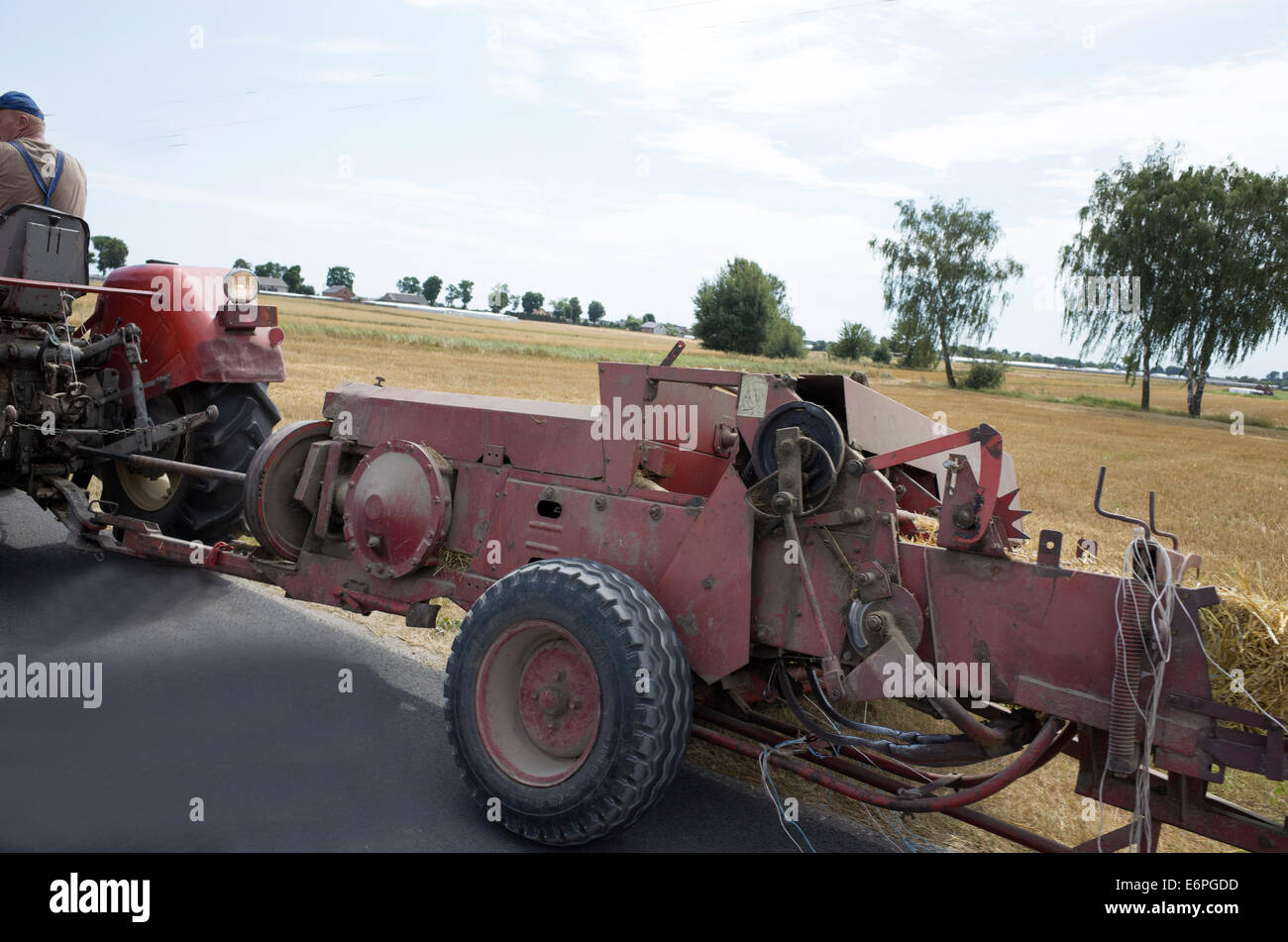 Fermier polonais de la traction d'une presse à balles de foin derrière son tracteur. Zawady Pologne Banque D'Images