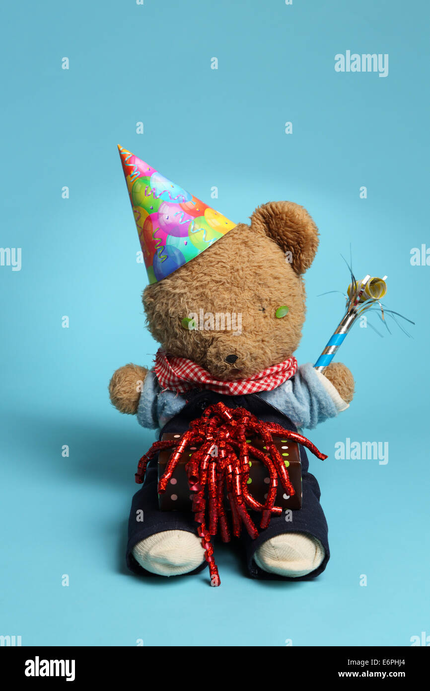 Un ours en peluche dans un party hat avec don et de la soufflante Banque D'Images
