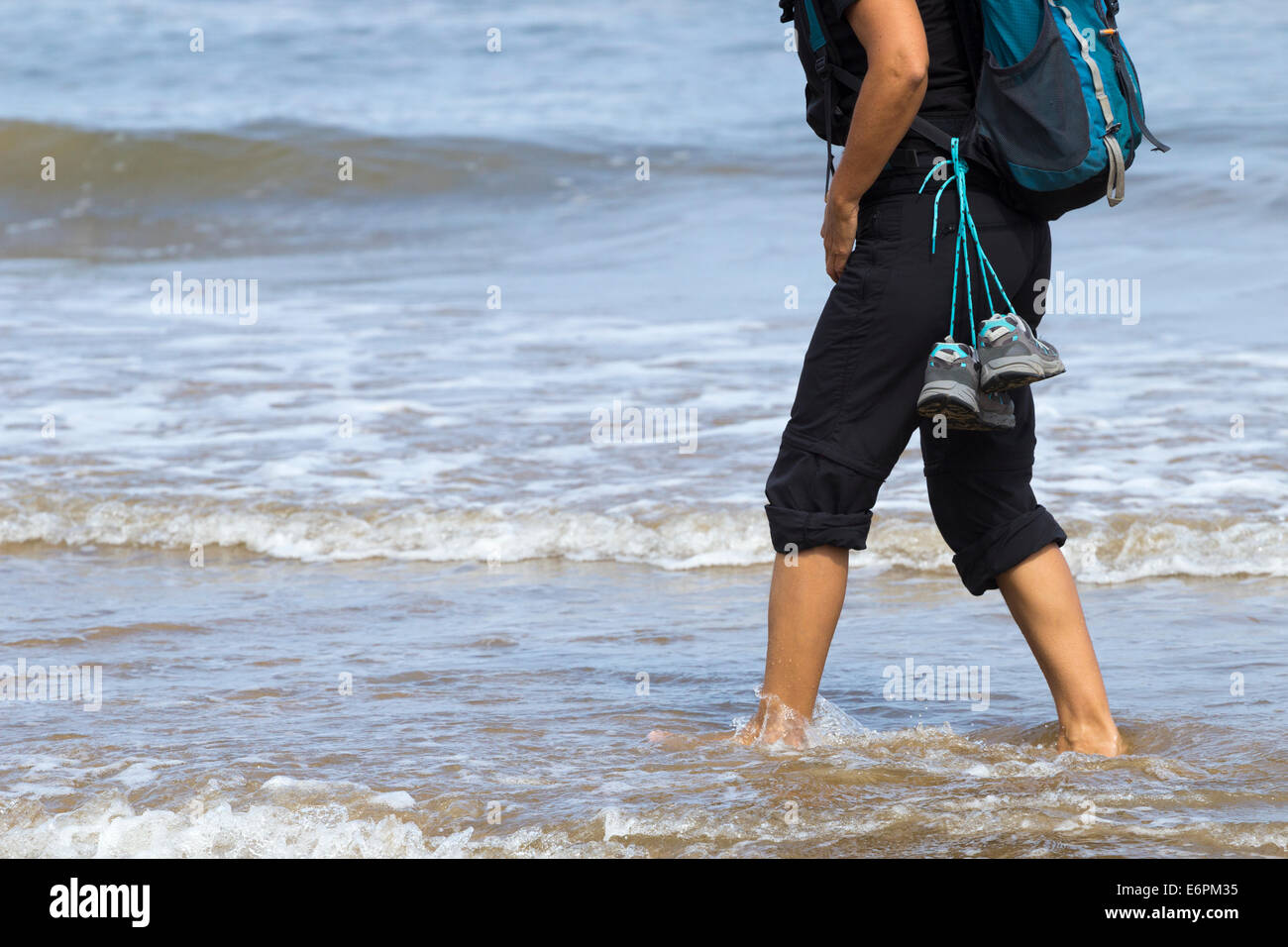 Backpacker femme marchant le long de la plage Banque D'Images