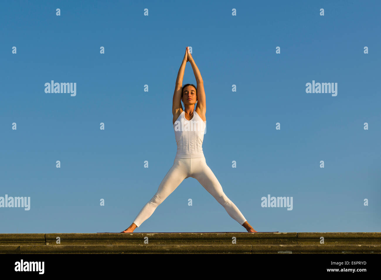 Jeune femme la pratique de l'Hatha Yoga, à l'extérieur, montrant la pose Tadasana, posture de la montagne, avec les jambes Banque D'Images