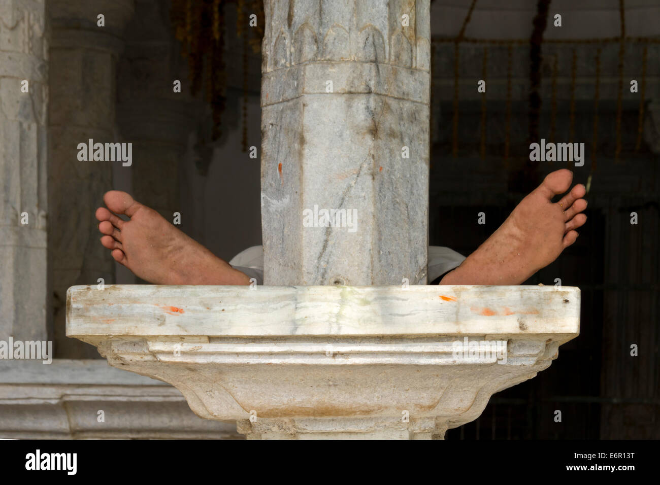 L'homme dormait sur un pilier de marbre dans un petit temple à Udaipur, Rajasthan, Inde Banque D'Images