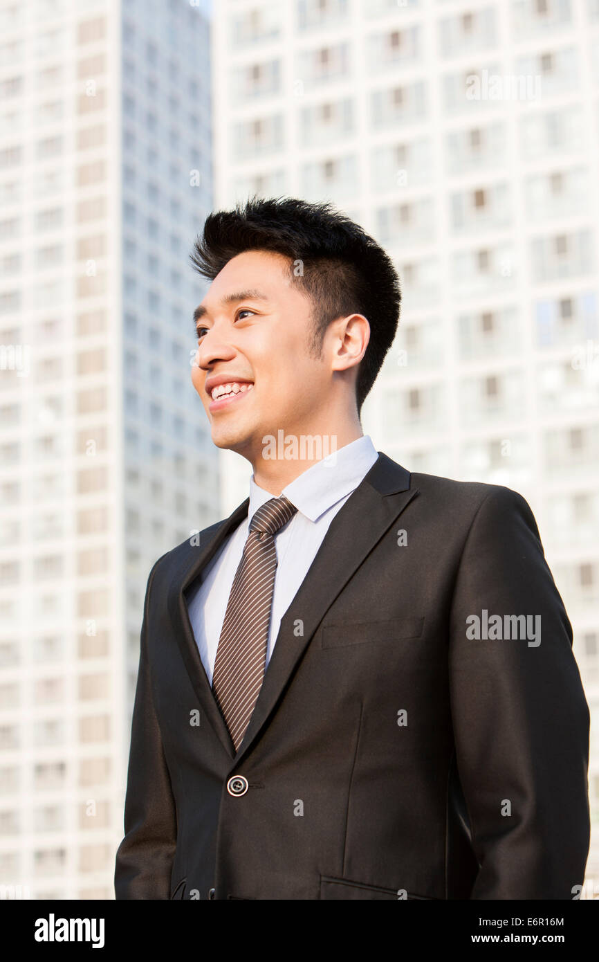 Happy young businessman looking at view in downtown district Banque D'Images