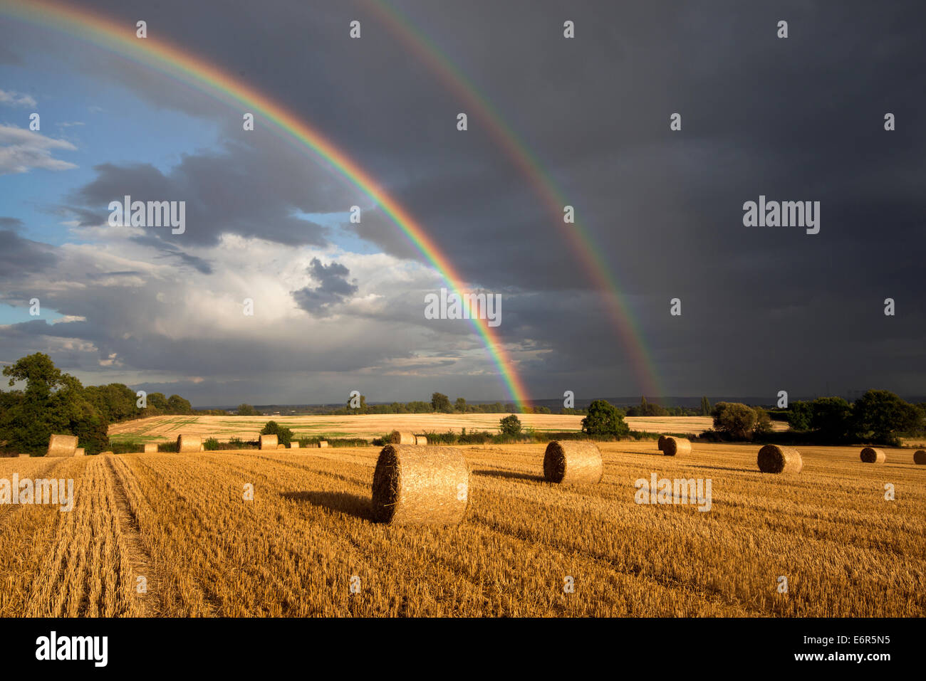 Lumière du soir orageux et un double arc-en-ciel dans un champ de bottes de foin, Stanton par Dale dans le Derbyshire Banque D'Images