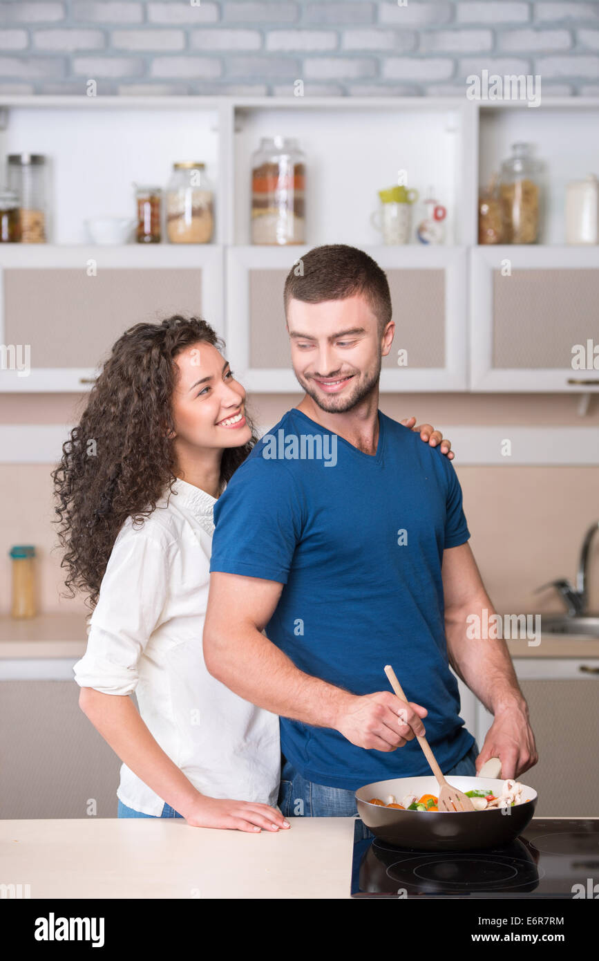 Couple heureux de préparer le souper et regarder Banque D'Images