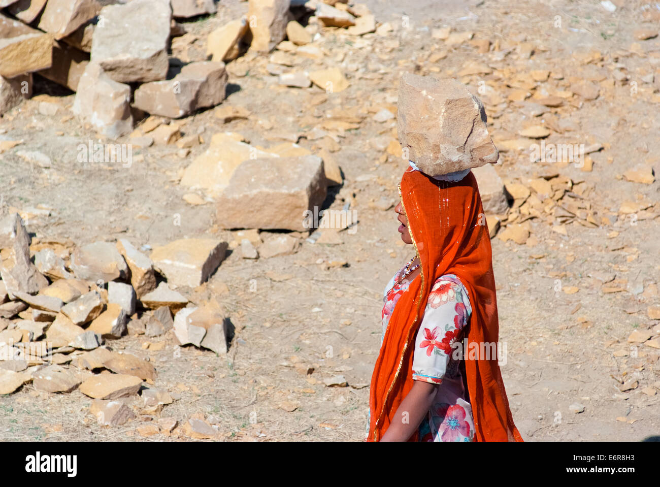 Une femme porte une brique sur la tête sur un chantier de construction le 25 février 2013 à Jaisalmer, Inde. Banque D'Images