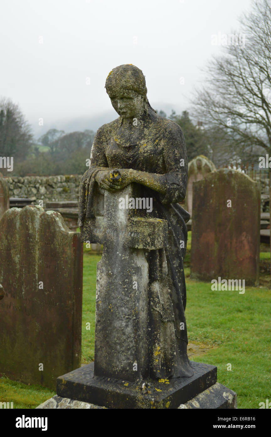 Dame solennelle avec croix de pierre tombale dans un cimetière en dehors de Abbaye de Sweetheart, dans la région de Dumfries et Galloway, Écosse Banque D'Images