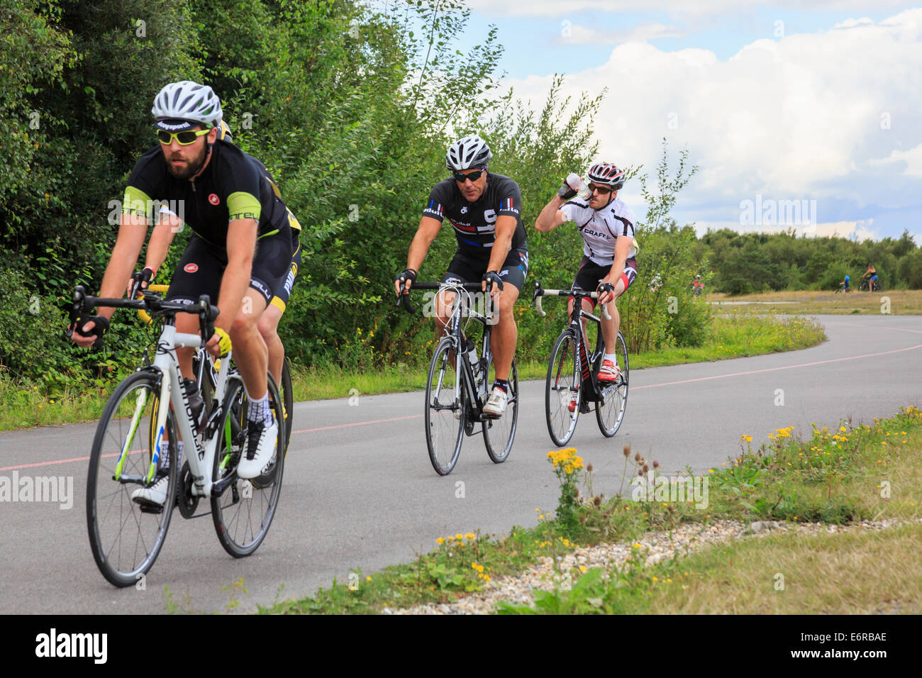 L'eau potable cycliste course dans une course de vtt organisée par British Cycling à Fowlmead Country Park Kent England UK Banque D'Images