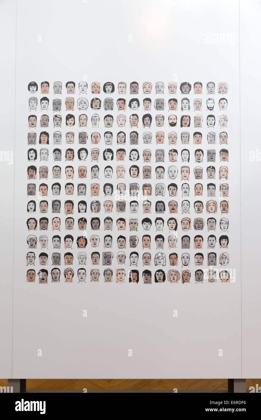 Dessins de races différentes visages sur un mur blanc. La verticale Banque D'Images
