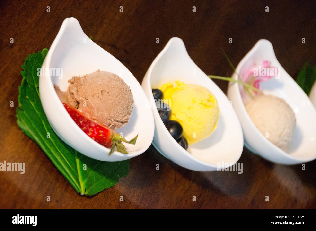 Bol de chocolat ou sorbet gelato avec fraise, à côté d'un bol de sorbet au citron et un bol de café ou de sorbet à la vanille Banque D'Images